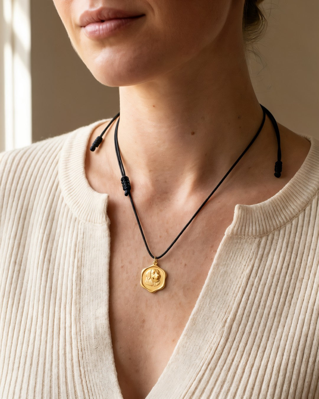 The medallion worn on its black cord, shown at true size